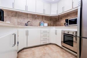 a white kitchen with white cabinets and appliances at ELEGANT Kata sea View Apartmens in Kata Beach +40 photos