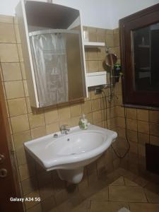 a bathroom with a white sink and a mirror at Villa Amalia - mansarda B&B in Cinisi