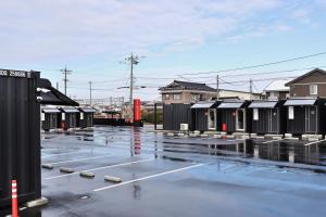 a parking lot with a bunch of black buildings at HOTEL R9 The Yard Uozu in Motoshin