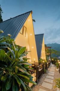 a house with a black roof and some plants at The Alchemist Rishikesh in Birbhaddar