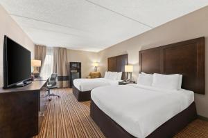 a hotel room with two beds and a flat screen tv at Comfort Inn Lehigh Valley West in Fogelsville