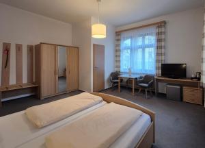 a bedroom with a bed and a desk and a television at Villa Steiermark in Bad Reichenhall