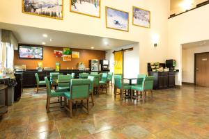 a dining room with green chairs and a restaurant at Quality Inn & Suites South Fork - Wolf Creek in South Fork