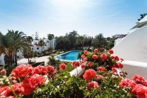 einen Blick vom Balkon eines Resorts mit roten Blumen in der Unterkunft Coral Beach Aparthotel in Marbella