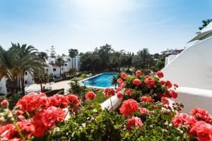 una vista dal balcone di un resort con fiori rossi di Coral Beach Aparthotel a Marbella