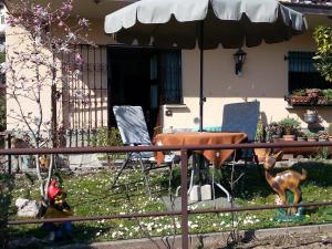 メナッジョにあるCO.RI. Appartamenti Dependanceの庭にテーブルと椅子、傘