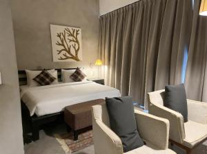 a hotel room with a bed and two chairs at Talent Residence in Phnom Penh