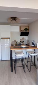 a kitchen with a table and two stools in it at bambou studio in Les Avirons