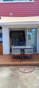a patio with a table and two benches on a porch at bambou studio in Les Avirons +2 photos