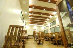 a dining room with wooden tables and chairs at Fair Stay Hotel in Cochin