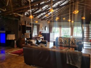 a living room with a leather couch and chairs at The Darling Farmstyle B&B in Krugersdorp