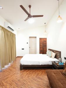 a bedroom with a bed and a ceiling fan at Tamarind Retreat in Alibaug +102 photos