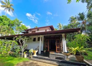a house in the middle of a garden at Priyanka Villa in Bentota