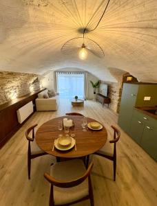 a dining room and living room with a table and chairs at La Cave in Marcigny
