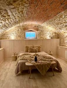 a bedroom with a large bed in a stone wall at La Cave in Marcigny