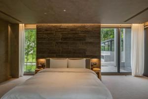 a bedroom with a large bed and large windows at Sokali Maho 蘇卡利 漫活 in Chung-chih-ts'un