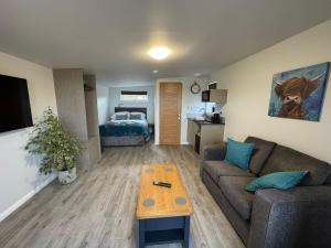 a living room with a couch and a table at Inverness Ardtower Escapes in Culloden