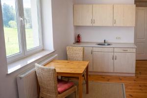 a kitchen with a wooden table and chairs and a sink at Pensjonat Kowalski in Łubowo