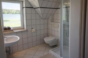 a bathroom with a toilet and a sink and a window at Pensjonat Kowalski in Łubowo +25 photos