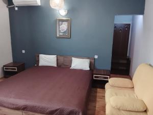 a small bedroom with a bed and a couch at Кащта за гости АРДА in Kŭrdzhali