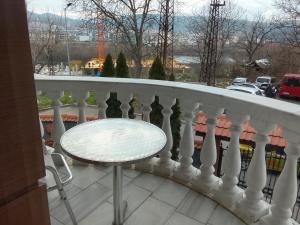 a white railing on a balcony with a table at Кащта за гости АРДА in Kŭrdzhali