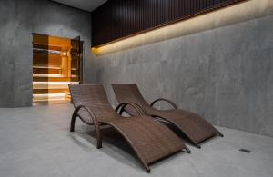 two rattan chairs sitting next to a wall at Al Anvar Halal Hotel by HotelPro group in Tashkent