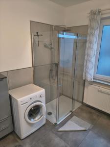 a bathroom with a washing machine and a shower at Ferienwohnung Wiebe in Minden +1 photo