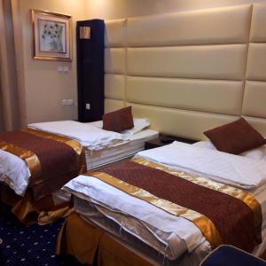 um quarto com três camas num quarto de hotel em Ajwaa Almsaa Wadi Ad Dawasir em Wadi Al Dawasir