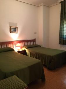 Cette chambre comprend 2 lits et une fenêtre. dans l'établissement Hostal Los Chopos, à Osorno