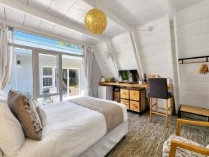 a bedroom with a bed and a desk and a window at Salt Boutique Guest House in Bloubergstrand +145 photos