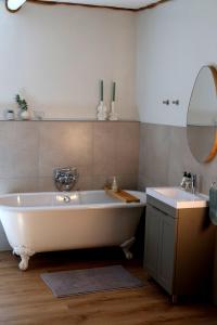a bathroom with a large white tub and a sink at Heiveld Farm Cottages in Ceres