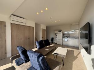 a living room with two couches and a tv at ひとめぼれ in Kumamoto +44 photos