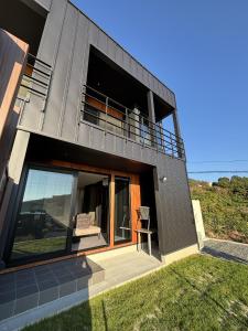 a modern house with a balcony and a lawn at ひとめぼれ in Kumamoto