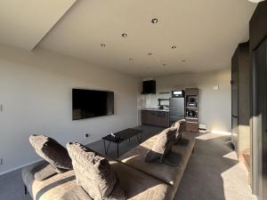 a living room with a couch and a tv at ひとめぼれ in Kumamoto