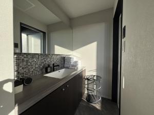 a bathroom with a sink and a mirror at ひとめぼれ in Kumamoto