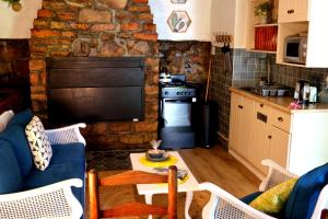 a kitchen with a living room with a stone wall at Heiveld Farm Cottages in Ceres +59 photos