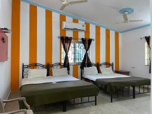 two beds in a room with orange and white stripes at Cardozo beach house in Calangute +40 photos