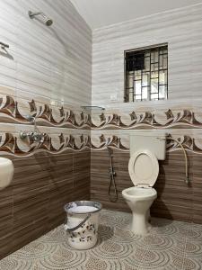 a bathroom with a toilet and a window at Cardozo beach house in Calangute