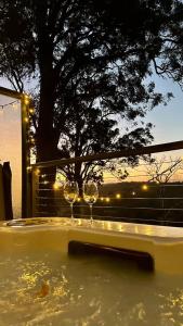 two wine glasses sitting in a bath tub with a tree at Scarlet Woods Chalets in Quinninup