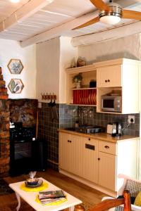 a kitchen with white cabinets and a table at Heiveld Farm Cottages in Ceres