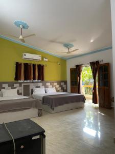a large bedroom with two beds and a window at Cardozo beach house in Calangute