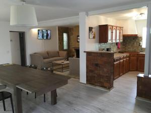 Una cocina y una sala de estar con una mesa y un sofá. en Villa des carassins, en Saint-Rémy-de-Provence