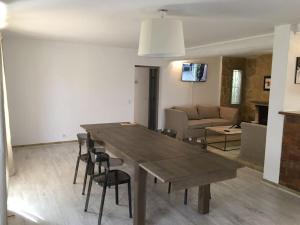 comedor y sala de estar con mesa de madera y sillas en Villa des carassins, en Saint-Rémy-de-Provence 7 fotos más