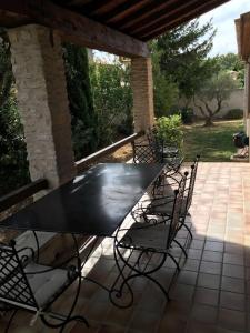 Una mesa y sillas negras en un patio. en Villa des carassins, en Saint-Rémy-de-Provence