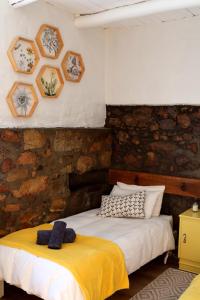 a bedroom with two beds and a stone wall at Heiveld Farm Cottages in Ceres