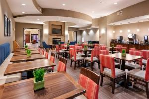 a restaurant with wooden tables and red chairs at Comfort Suites Goodyear-West Phoenix in Goodyear