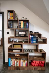 a book shelf filled with books in a room at Pepper Apartman Donji Miholjac in Donji Miholjac