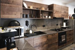 a kitchen with wooden cabinets and a stove top oven at Pepper Apartman Donji Miholjac in Donji Miholjac