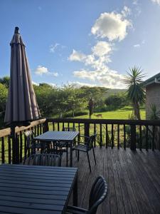 a deck with a table and an umbrella and chairs at Intibane Lodge in Ulundi