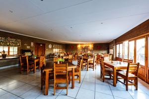 a dining room with wooden tables and chairs at Intibane Lodge in Ulundi